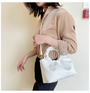 Modèle portant un sac à bandoulière en PU blanc plissé avec poignée à volants
