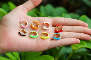 Close-up of eight colorful enamel U-shaped hoop earrings with sparkling zircon stones