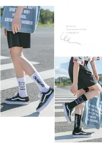 Gros plan de chaussettes en coton avec sourire graffiti et texte CALMMIND en noir et blanc