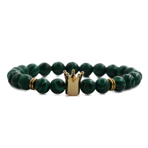 Detailed shot of malachite green beads and gold crown charm on a men's beaded bracelet