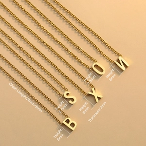 Golden stainless steel letter necklaces for women with 18K gold plating on warm background