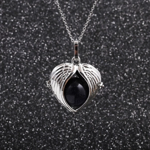 Stainless steel angel wing heart necklace with blue gemstone on black background