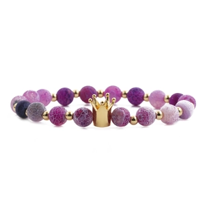 Pink and purple crackle agate bead bracelet with a gold crown charm on white background