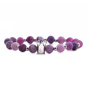 Detail of purple and pink agate beads with a silver crown charm on a stretch bracelet