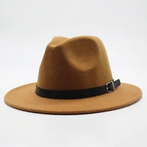 Détail d'un chapeau fedora en feutre camel avec ceinture en cuir noir et boucle argentée