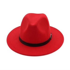 Détail d'un chapeau fedora rouge avec ruban noir et boucle métallique argentée