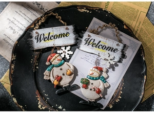Detail of Christmas snowman welcome signs with red scarves and rustic wooden plaques