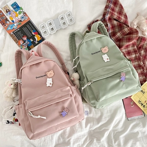 Detail of pink and green cute backpacks with bear pins and Duociyuan embroidery