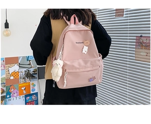 Pink canvas backpack detail with cute bear badges, embroidery and a plush bear pendant