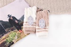 Flat lay of soft coral fleece striped sleep socks in beige and brown with lifestyle props