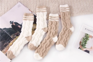 Flat lay of cable knit fuzzy sleeping socks in cream and white with stylish magazine props