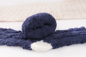 Close-up of soft navy blue coral fleece sleep socks with white polka dot pattern texture