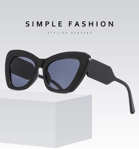 Detail view of bold cat-eye sunglasses featuring wide geometric temples and blue lenses