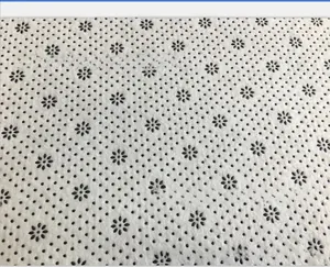 Macro detail of non-slip carpet backing with black plum blossom pattern dot grip