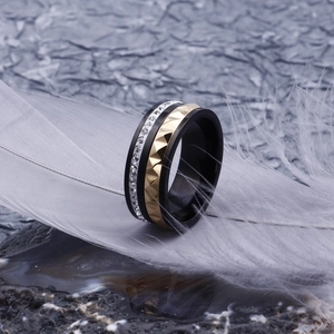 Vue détaillée d'une bague unisexe large avec base noire et motifs de pyramide dorés