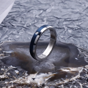 Macro shot of blue brushed and silver polished steel ring with inlaid small diamond