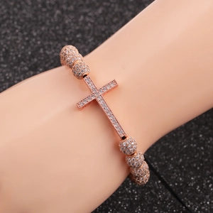 Rose gold cross bracelet with micro-p鑲 zircon beads on a black shimmering background
