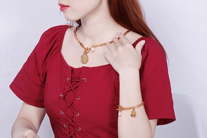Detail of gold pearl necklace and bracelet set with angel charm and toggle clasp