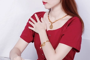 Détail du collier pendentif arbre doré et bracelet perles porté par un mannequin