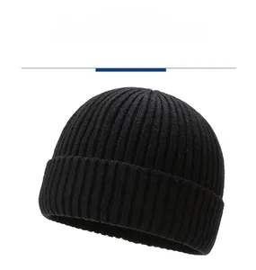 Close-up of black ribbed knit beanie showing thick vertical texture and folded cuff style