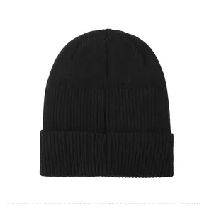 Detail view of the ribbed knit texture and cuffed hem on a black winter beanie