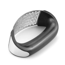 Detail of stainless steel garlic press with curved hole pattern and black handle