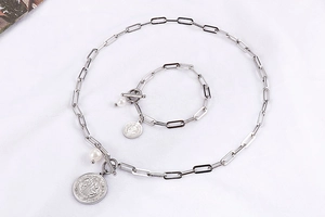 Détail de l'ensemble collier et bracelet en acier titane avec perles et fermoir à bascule
