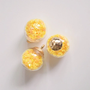 Detailed view of 16mm glass globes with yellow star sequins and golden metal loops