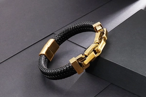 Detailed shot of men's braided black leather bracelet with gold stainless steel hardware