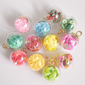 Macro shot of colorful glass ball charms with glitter stars and fruit slices for jewelry
