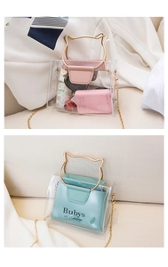 Detail of transparent PVC jelly bag featuring gold cat ear metal handles and chain strap