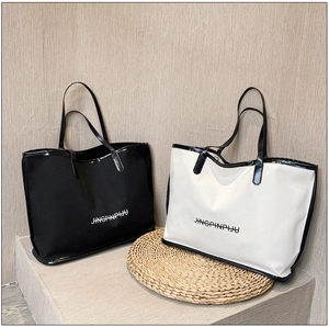 Detail view of large canvas tote bags in black and beige with durable PU leather handles