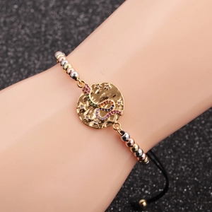 Detail of beaded snake bracelet with colorful cubic zirconia and gold charm pendant