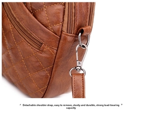 Detail of the detachable shoulder strap with silver metal clasp on brown quilted leather bag