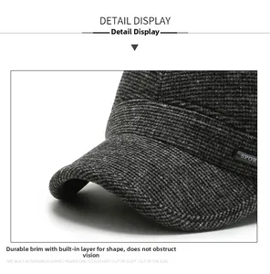 Detail of grey textured winter flat cap showing a sturdy brim and sports label