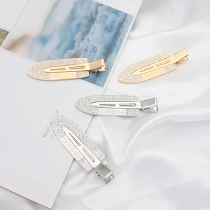 Sparkling rhinestone metal hair clips in gold and silver set on white silk background