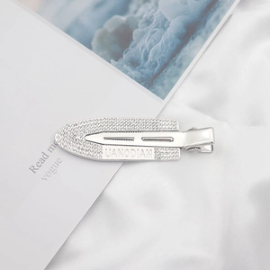 Detail showing crystal rhinestone surfboard hair clip with UANODIAM engraved silver finish