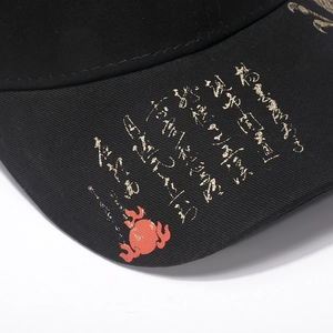 Close-up of black cotton baseball cap with gold Chinese calligraphy and red totem