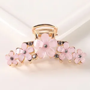 Detailed close-up of gold-plated alloy hair claw featuring pink opal-like flowers and crystals
