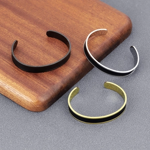 Detailed comparison of minimalist men's open bangles in black, silver, and gold finishes