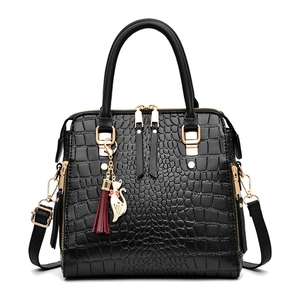Schwarze Henkeltasche mit Krokodilmuster, goldener Hardware und Katzen-Quasten-Anhänger