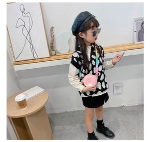 Pink round crossbody kids bag with rainbow adjustable strap in modern lifestyle setting