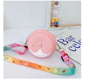 Close-up of pink round silicone kid bag with 3D rocket design and rainbow strap