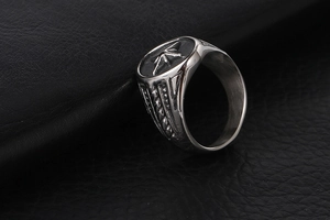 Detailed macro shot of vintage silver steel ring with star engraving on leather background
