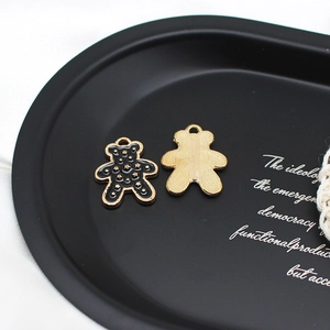 Pendentifs ours en alliage noir et or pour bijoux DIY présentés sur un plateau