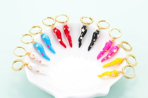 Detailed view of six pairs of gold hoop earrings with colorful chili and star charms