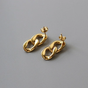 Macro detail of 18K gold-plated double-link chain stud earrings with polished finish