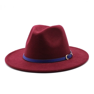 Detail of burgundy felt fedora hat featuring a slim blue band and golden metal buckle