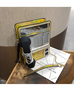 Bolso bandolera holográfico en forma de teléfono con acabado metálico y cadena dorada.