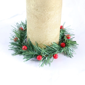 Christmas candle ring with artificial pine needles and red berries for festive home decor